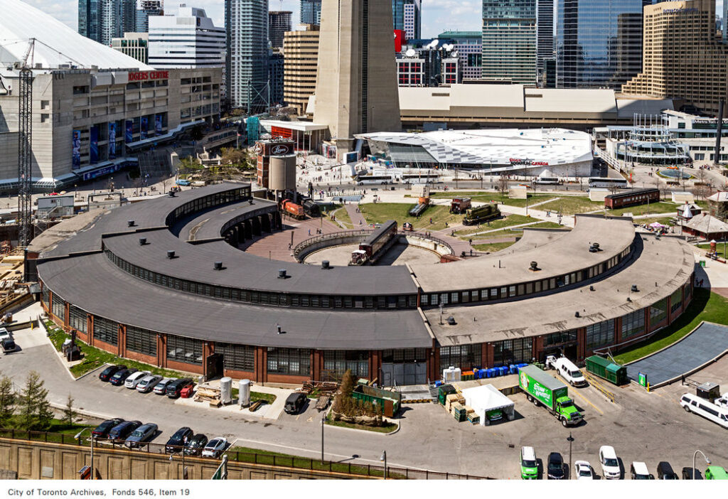 Aerial view of the John Street Roundhouse taken from the south end. Steam Whistle Brewery is located in the segment on the right with the lighter roof. The Toronto Railway Museum occupies the darker roofed segment on the left. Photo taken on May 2, 2015 by Vik Pahwa, Fonds 546, Item 19, City of Toronto Archives www.toronto.ca/archives